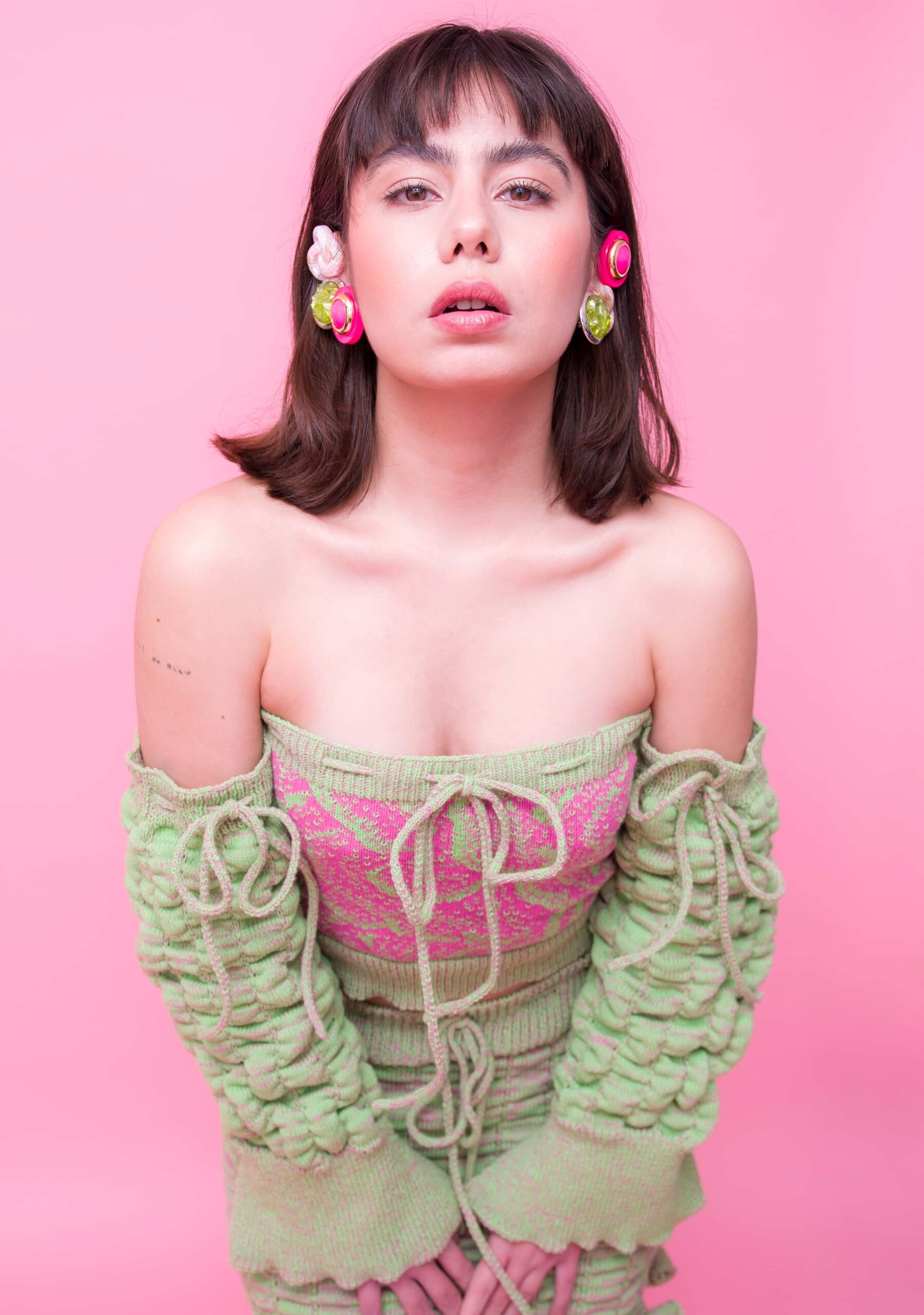 Multiple earrings on model with pink background