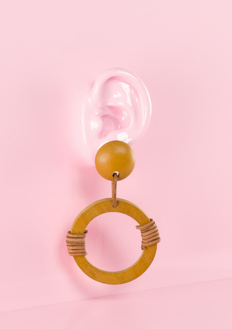 Brown wooden drop earrings on pink background