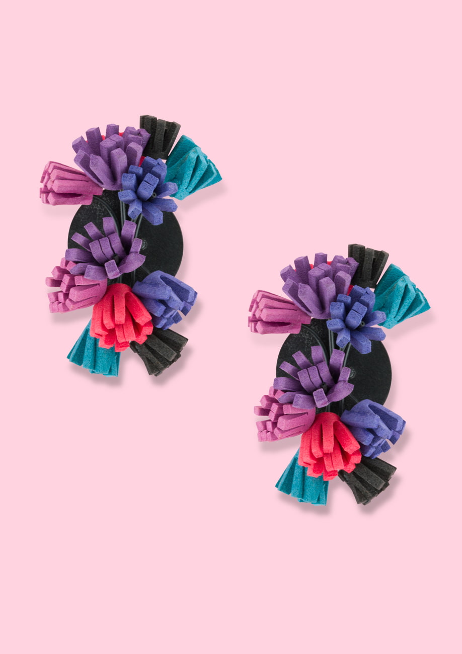 Purple statement earrings with foam fringes and a clip closing