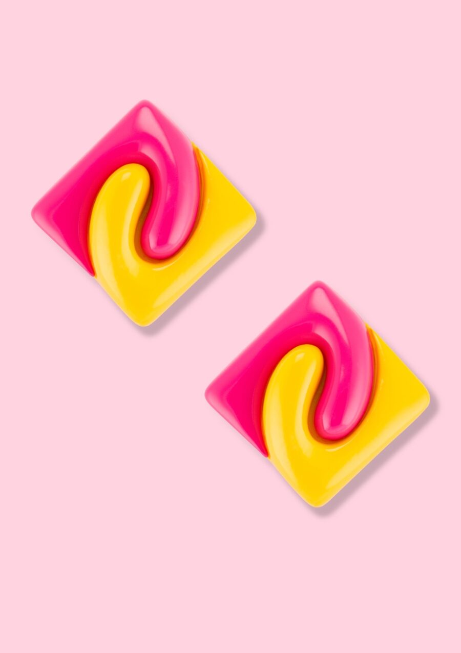Square sustainable stud earrings on a pink background